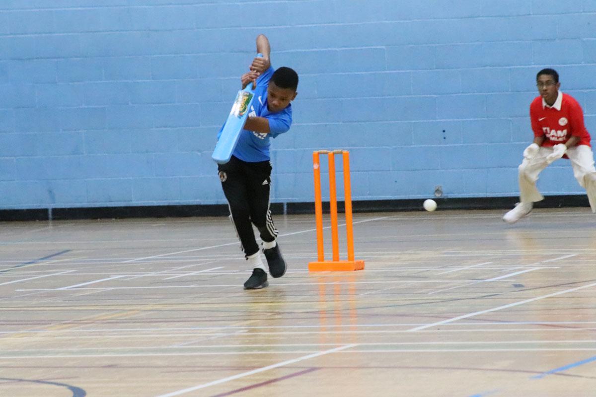 black boy hitting cricket ball