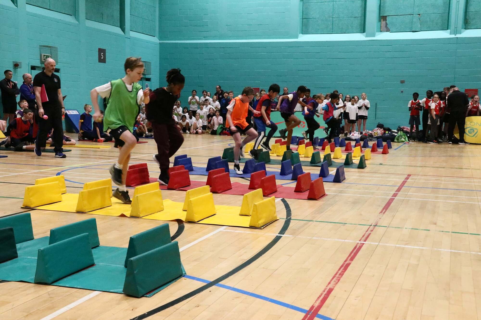 Children playing with blocks on a gym floor.