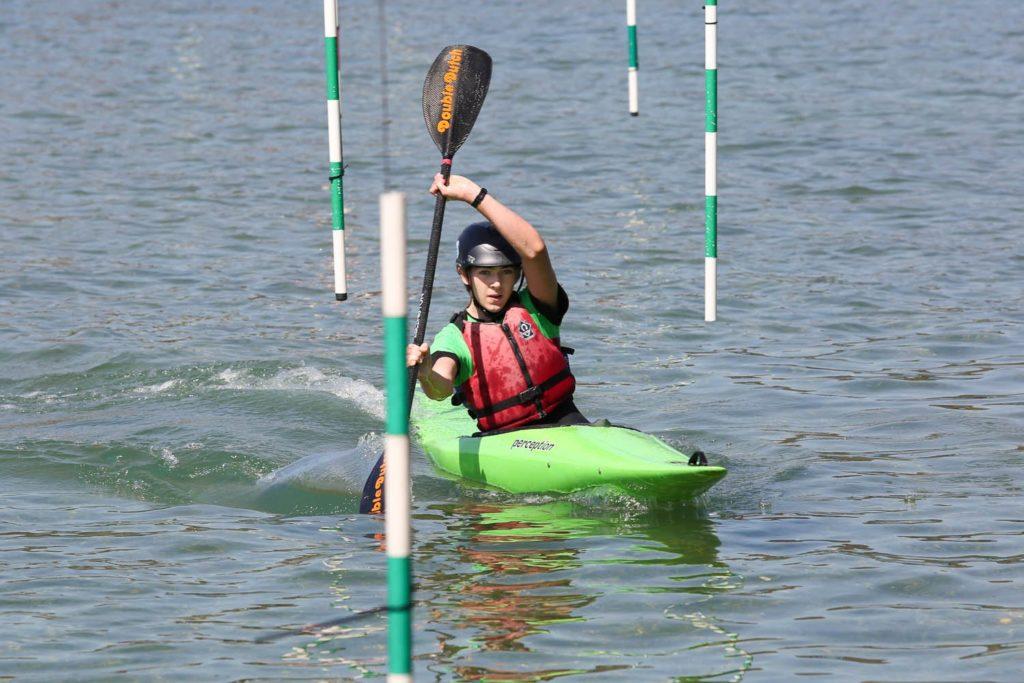 A person in a kayak paddling on calm water.