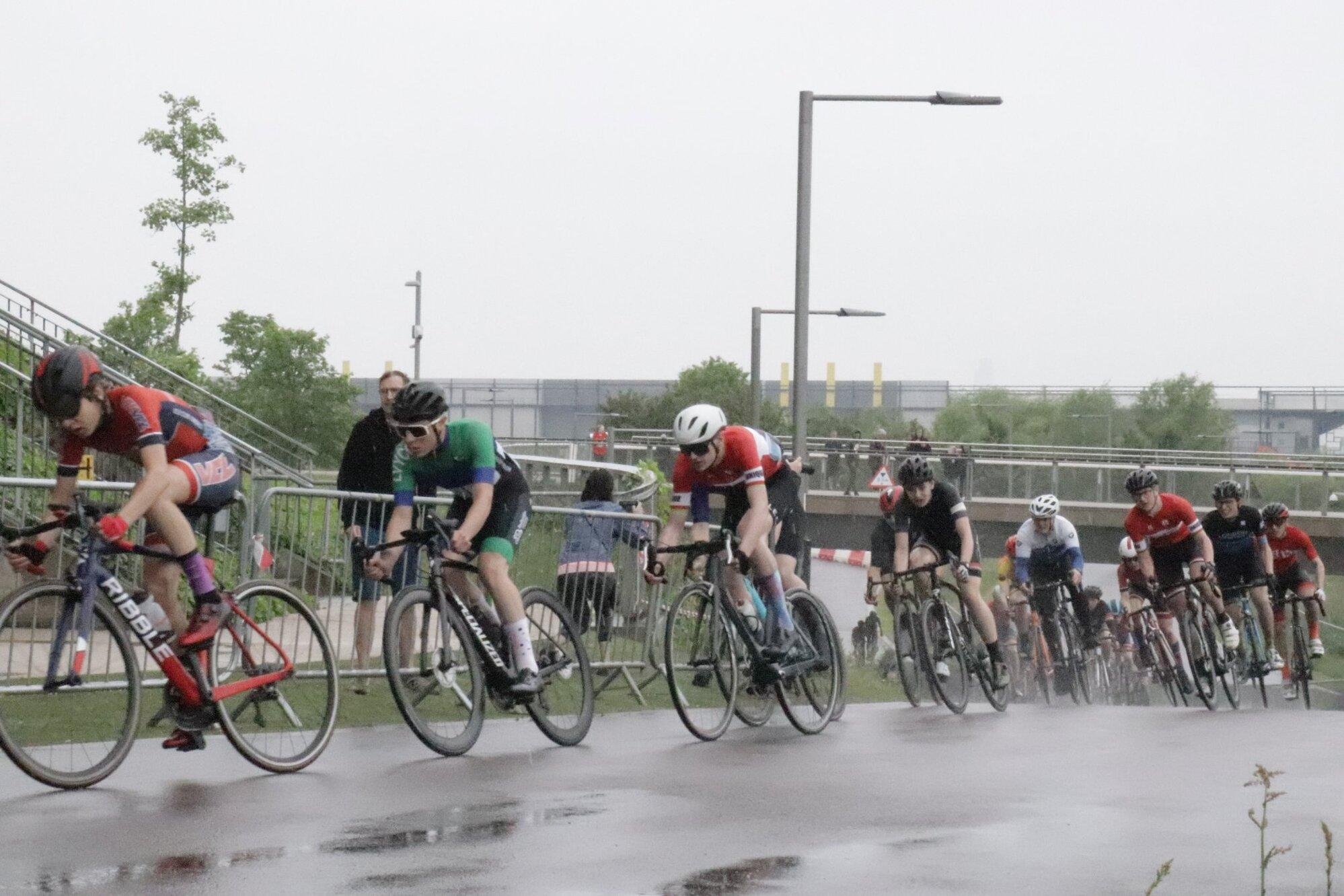 Cyclists riding in a group on the road during a cycling event.