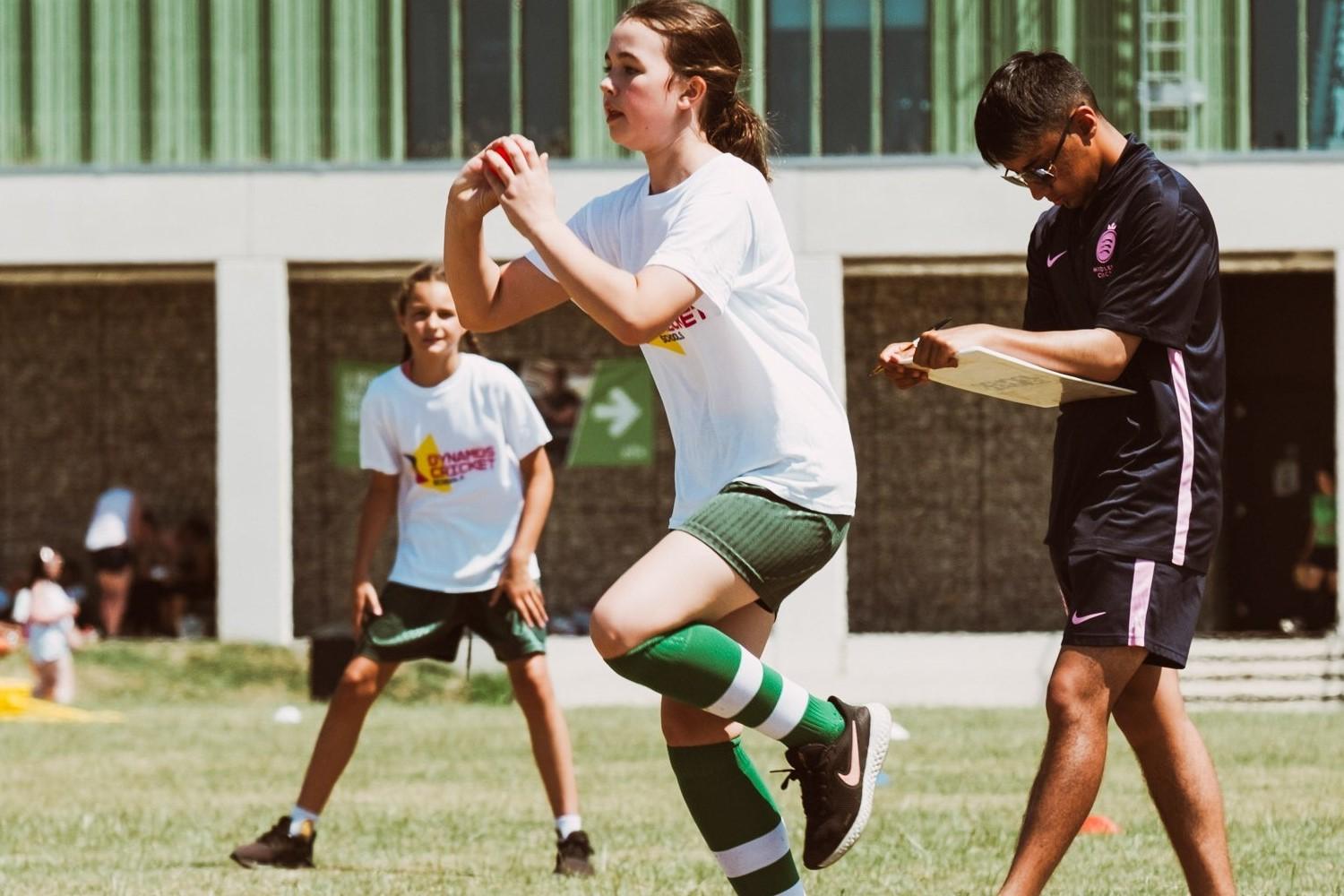 A girl bowling a cricket ball.