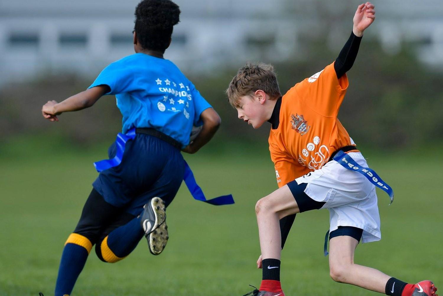 Two young boys playing soccer on a field.