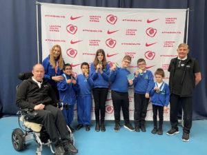 6 boccia players pose with their medals, their teachers and the Boccia staff