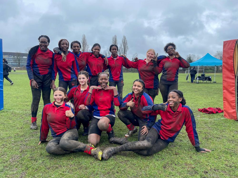 12 female rugby players pose for a photo