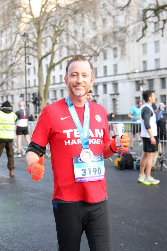 Craig smiling with a thumbs up at a race