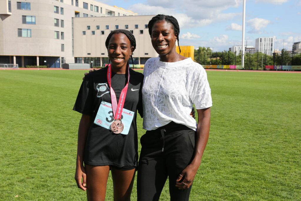 black athletics girl stands next to Christine Ohuruogu