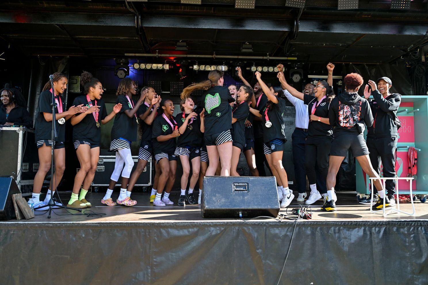 group of basketball girls celebrate winning trophy