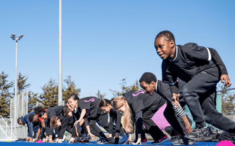 mixed ethnicity school children smile and run