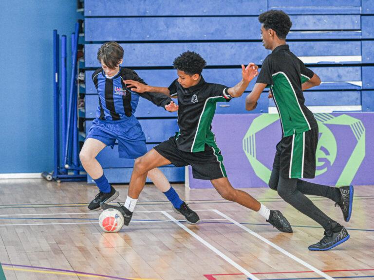 mixed ethnicity boys play futsal