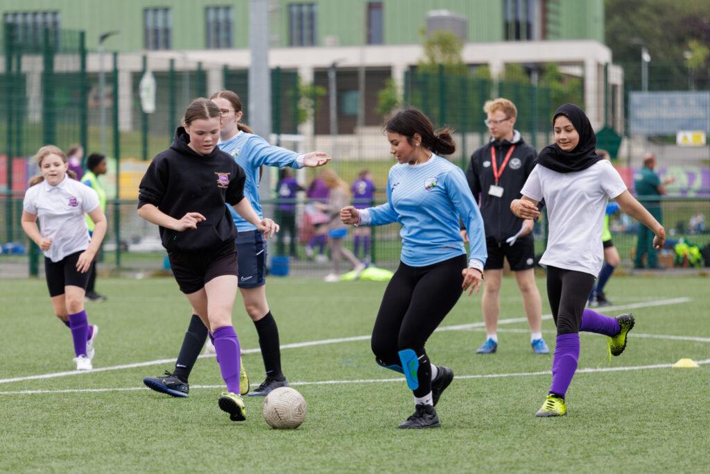 Mixed ethnicity girls play football