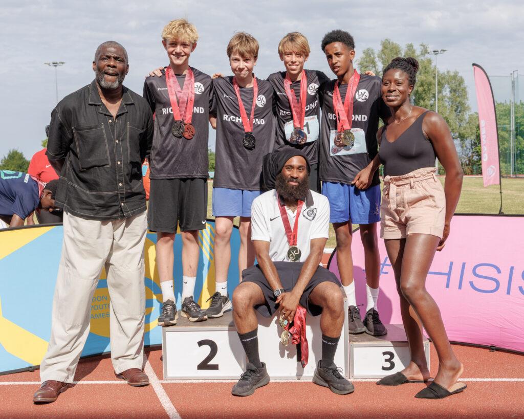 ethnically diverse boys smile with Christine Ohuruogu and Geoff Thompson