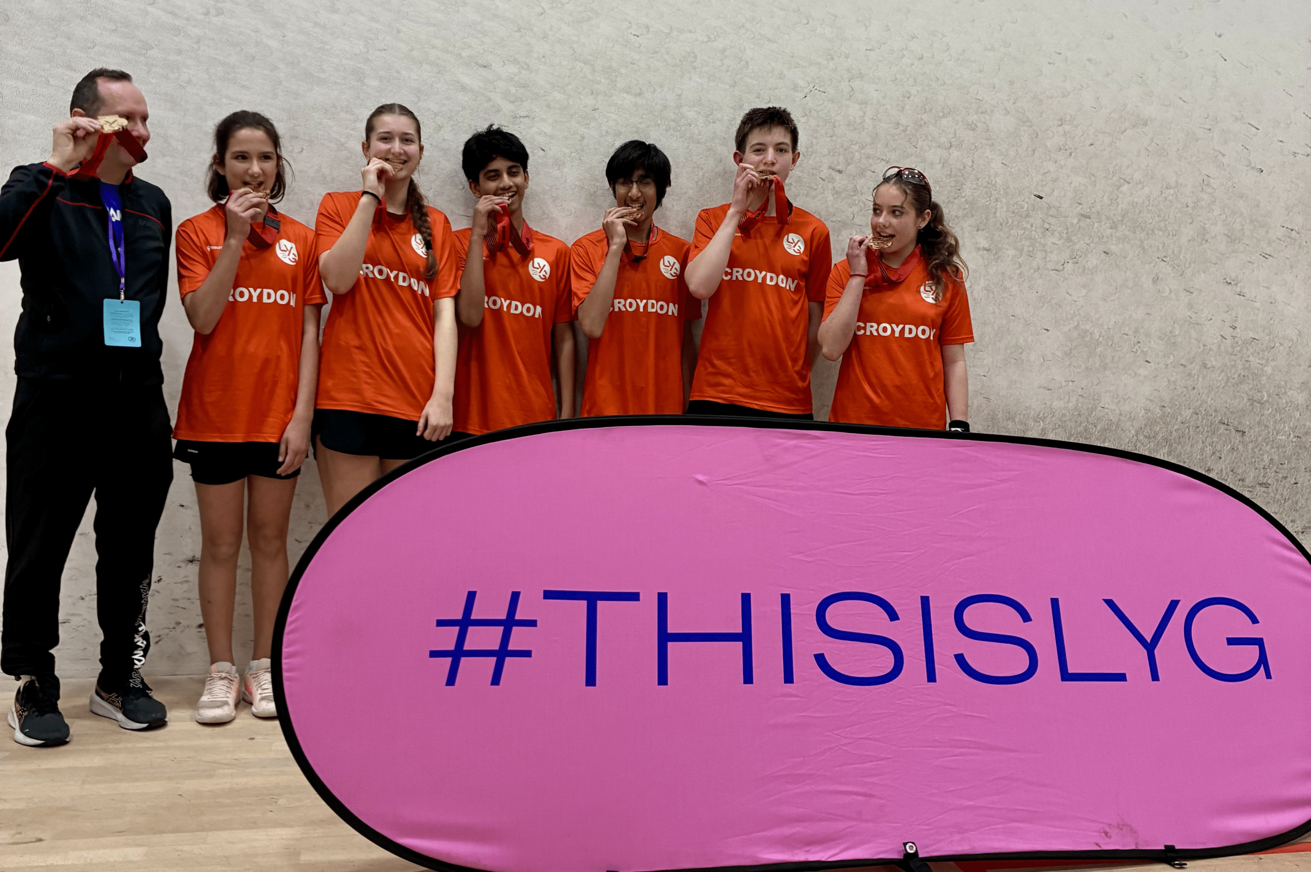 ethnically diverse boys and girls from Croydon smile with gold medals