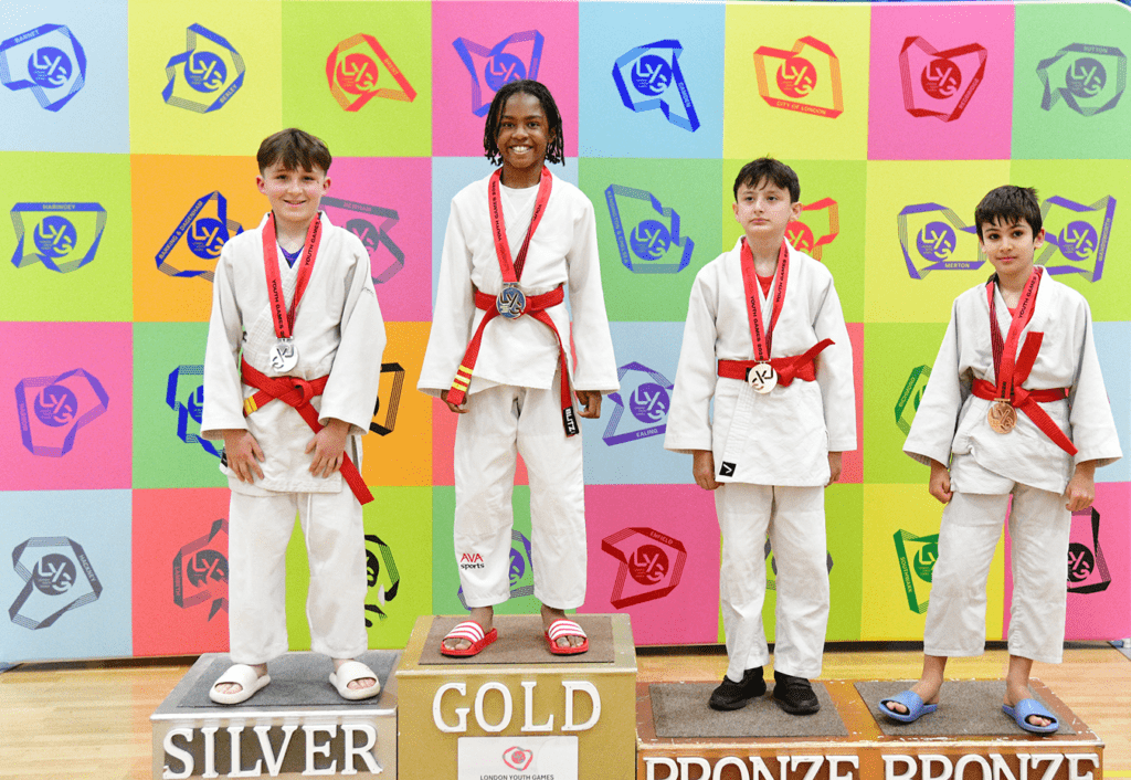 mixed ethnicity red belt judokas smile