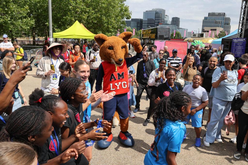 LYG mascot dances and people cheer