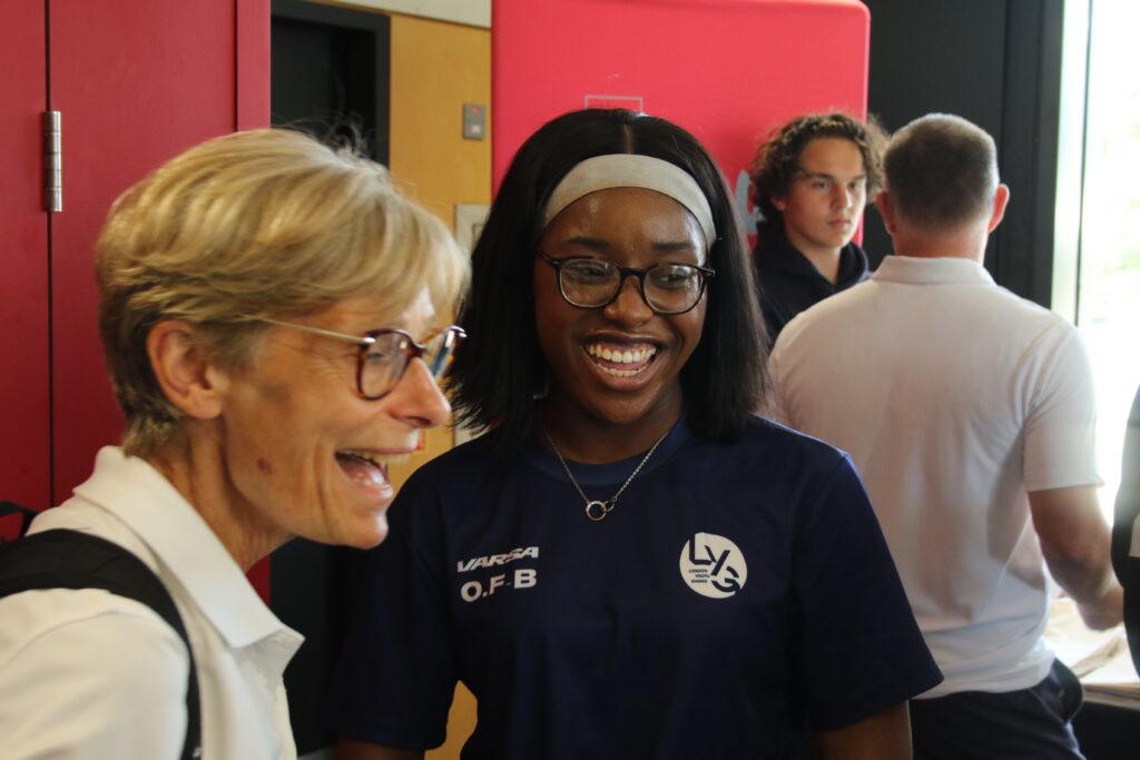 1 black young female and 1 white female smiles